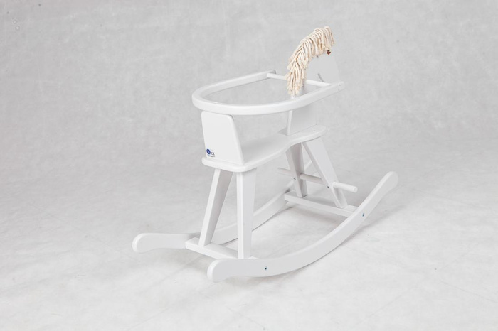 Biały, drewniany koń na biegunach z obejmą