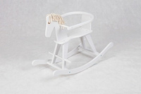 Biały, drewniany koń na biegunach z obejmą