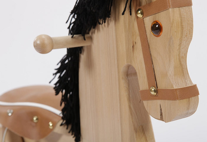 Drewniany koń na biegunach. Piękny rumak z siodłem