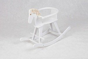 Biały, drewniany koń na biegunach z obejmą